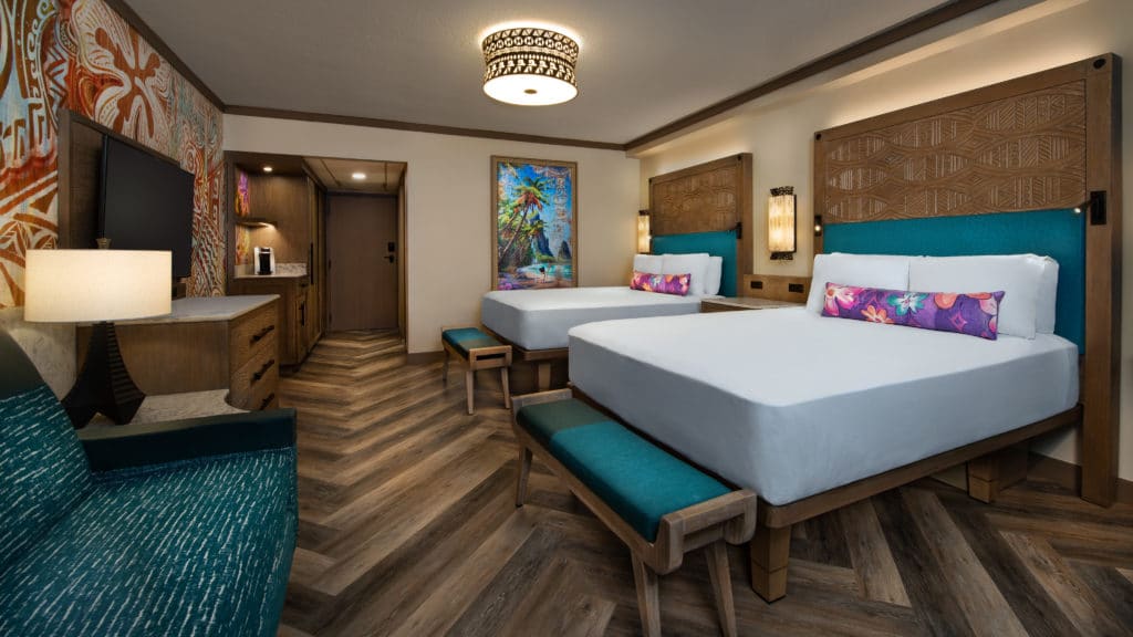 A room like this with turquoise touches, floral fabrics, wood carvings, and a general relaxed island atmosphere is what you can expect at Walt Disney World's Polynesian Village Resort