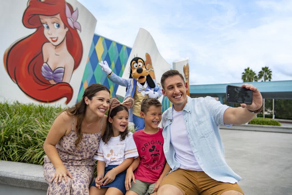 Families like this one with two young kiddos like this one, love to pose in front of all the wonderful details and colorful characters such as Goofy at the Art of Animation Resort in Walt Disney World.