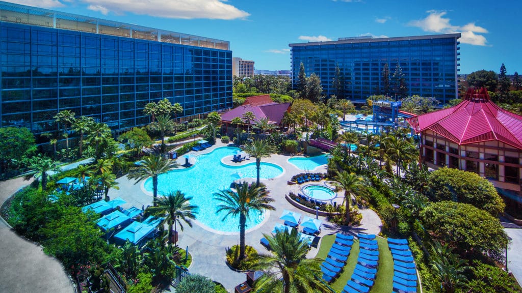 A stunning bright blue pool, surrounded by lush palm trees and plenty of comfy seating areas await you at the Disneyland Resorts- as evidenced by these overhead views of the lovely property outside the Disneyland Hotel.