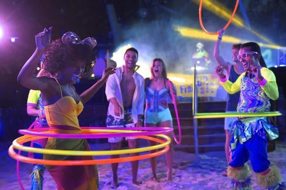 These adults were clearly able to find the best Disney World resort for adults as they are seen having nighttime fun with glowing hula hoops and drinks and party lights on the Florida beach.