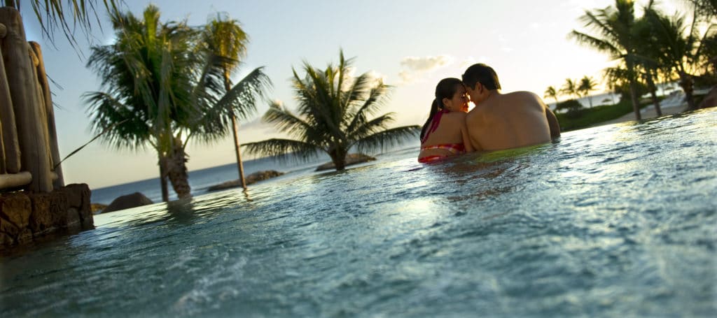 Endless possibilities for romance with a honeymoon at Disney World or Disneyland or Disney's Aulani Resort in Hawaii, as this snuggling couple chose so they could enjoy the sunset from the pools with an ocean view.