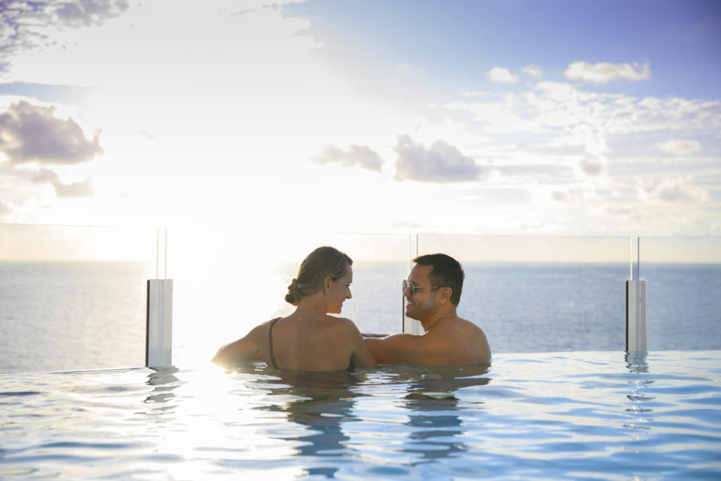 A loving couple watches the sun go down from the adults-only Quiet Cove Pool which is a staple onboard all of the Disney ships in the Disney Cruise Line fleet