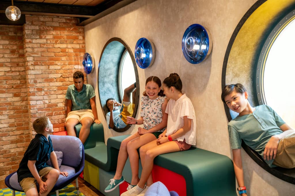 Disney ships are equipped with youth clubs for all ages - like this fun "Edge" hangout for tweens where you can see a bunch of kids talking and laughing and relaxing on vacation together